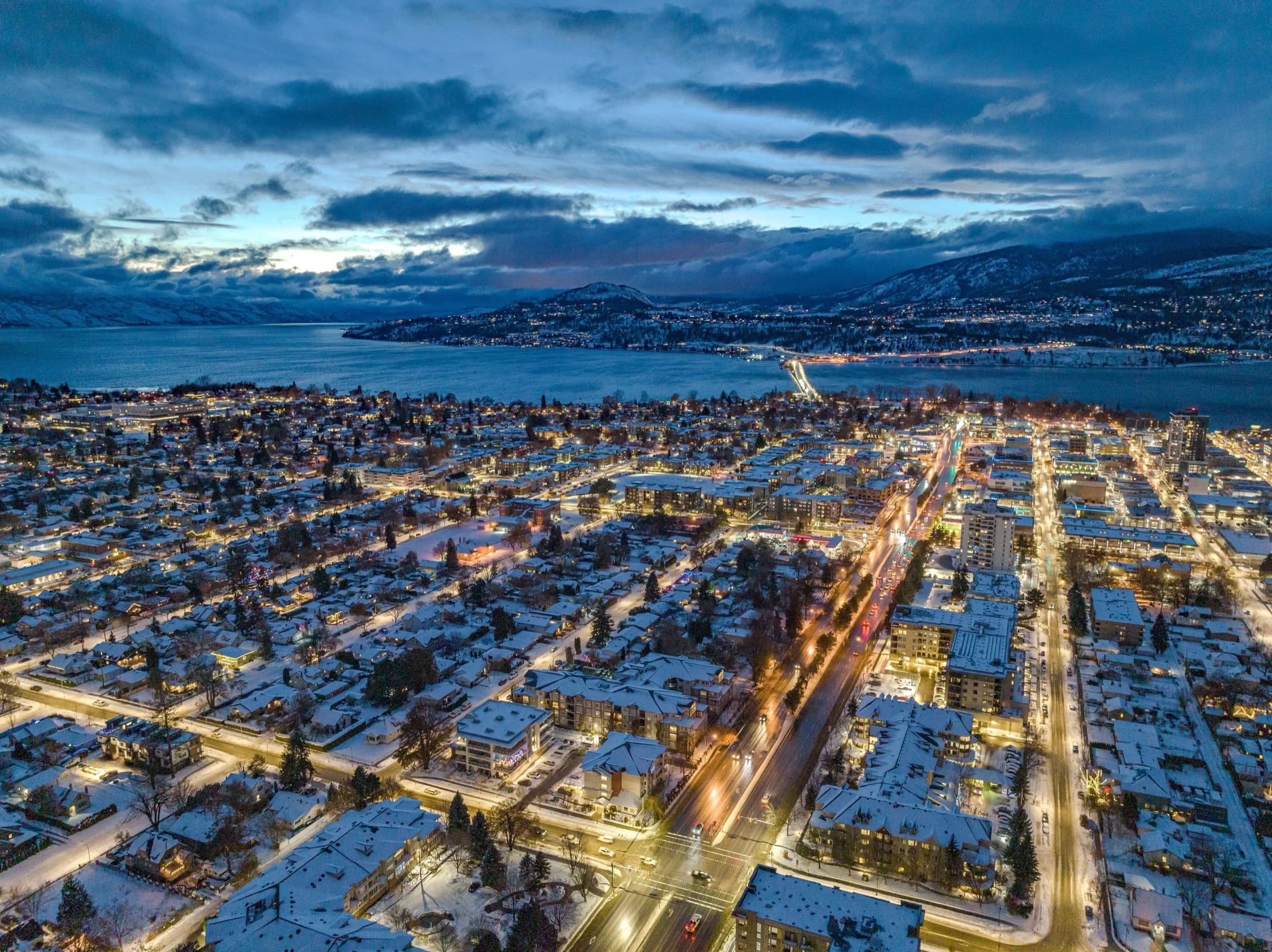 Aerial view of Kelowna at dusk, looking out over Okanagan Lake